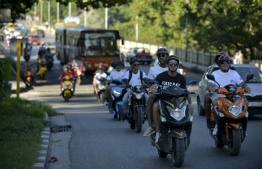 Electric motorcycle riders have come to the rescue of Cuban passengers delayed by fuel shortages. PHOTO: YAMIL LAGE / AFP