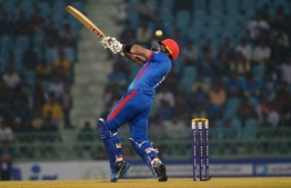 Afghanistan's Mohammad Nabi plays a shot during the third one day international (ODI) cricket match between Afghanistan and West Indies at the Ekana Cricket Stadium in Lucknow on November 11, 2019. (Photo by Rohit UMRAO / AFP) / 