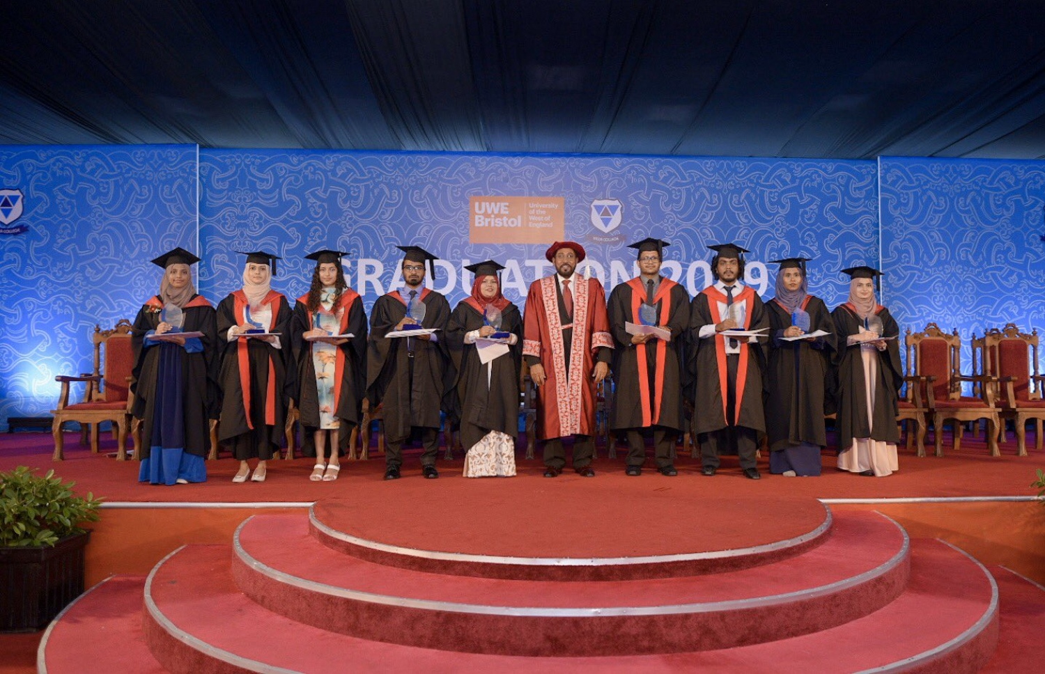 ވިލާ ކޮލެޖުގައި ހިންގާ ޔޫވީގެ ޕްރޮގްރާމްތަކުން ވަނަ ހޯދި ދަރިވަރުންނާއެކު، އެ ކޮލެޖުގެ ފައުންޑަރު ގާސިމް  ފޮޓޯއަކަށް ހުއްޓިލައިގެން - ފޮޓޯ: ވިލާ ކޮލެޖު