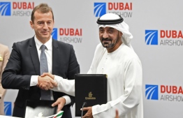 Ahmed bin Saeed Al Maktoum (R), CEO and chairman of the Emirates Group, and Guillaume Faury, Airbus CEO, pose for a picture after the signing of an agreement during the Dubai Airshow on November 18, 2019. - Emirates Airline said it will buy 50 Airbus 350-900 aircraft in a deal worth $16 billion, with delivery to begin from May 2023. (Photo by KARIM SAHIB / AFP)