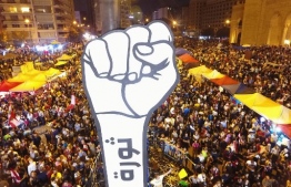 (FILES) In this file photo taken on November 10, 2019, Lebanese demonstrators raise a large clenched fist with the slogan "revolution" written on it in Arabic in Beirut's Martyrs Square during continuing anti-government protests in the centre of the Lebanese capital. (Photo by - / AFP)