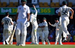 Australia's players celebrate the dismissal of Pakistan's batsman Asad Shafiq on day three of the first Test cricket match between Pakistan and Australia at the Gabba in Brisbane on November 23, 2019. (Photo by Saeed KHAN / AFP) / 
