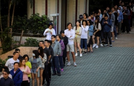 People queue to cast their vote during the district council elections in South Horizons in  Hong Kong on November 24, 2019. - Hong Kong voted in district council elections in a ballot the city's pro-democracy movement hoped would send a message to the Beijing-backed government. (Photo by VIVEK PRAKASH / AFP)
