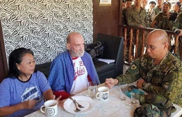 In this undated handout photo released by Western Mindanao Command (WESMINCOM), British couple Wilma (L) and Allan Hyrons eat a meal at a military camp in Sulu island, after their rescue from Islamic State-linked militants. - Philippine soldiers on November 25 rescued a British man and his wife from Islamic State-linked jihadists nearly two months after the couple was kidnapped from their beach resort in the nation's south, authorities said. (Photo by STRINGER / Western Mindanao Command / AFP) / 