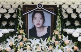 The portrait of late K-pop star Goo Hara is seen surrounded by flowers at a memorial altar at a hospital in Seoul on November 25, 2019. - Fans mourned and questions were asked November 25 after K-pop star and revenge porn victim Goo Hara was found dead in a possible suicide, which would make her the second female singer in a month to take her own life in the high-pressure industry. (Photo by str / Dong-A Ilbo / AFP) / 