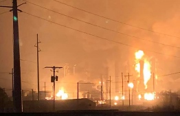 This handout image taken early on November 27, 2019 and released to AFP by Ryan Mathewson, who lives roughly two minutes from the plant with his family, shows fire and flames following an explosion at a chemical plant in the Texas city of Port Neches, east of Houston. - The massive explosion at the plant early on November 27 sent a large fireball into the sky, media reports said, triggering a mandatory evacuation. (Photo by Handout / Courtesy of Ryan Mathewson / AFP) / 