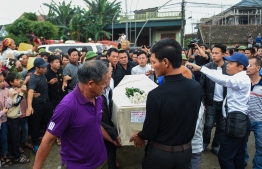 Crowds look on as relatives carry the casket bearing the body of Nguyen Van Hung arrives in Dien Chau district, Nghe An province on November 27, 2019 after being repatriated from Britain. - The first remains of the 39 people found dead in a truck in Britain last month arrived in Vietnam early November 27, capping a weeks-long wait by families eager to bury their loved ones. (Photo by Nhac NGUYEN / AFP)