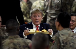 US President Donald Trump serves Thanksgiving dinner to US troops at Bagram Air Field during a surprise visit on November 28, 2019 in Afghanistan. (Photo by Olivier Douliery / AFP)