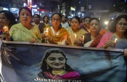 Supporters of Bharatiya Janata Party (BJP) hold candles and a banner as they participate in a candle light procession calling for justice following the recent rape and murder case of a 27-year-old veterinarian in Hyderabad, in Siliguri on November 30, 2019. - Hundreds of people on November 30 laid siege to a police station where four men are being held over the latest gruesome rape-murder to shock India. Baton-wielding police pushed back crowds from the building in the southern city of Hyderabad where they said the 27-year-old veterinary doctor was gang-raped, killed and then her body burned. (Photo by DIPTENDU DUTTA / AFP)