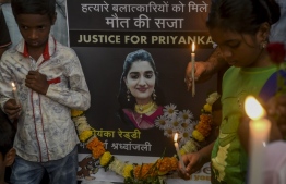 Children hold candles during a prayer meeting demanding justice for the rape and murder of a 27-year-old veterinary doctor from Hyderabad, in Mumbai on December 1, 2019. - Hundreds of people on November 30 laid siege to a police station where four men are being held over the latest gruesome rape-murder to shock India. Baton-wielding police pushed back crowds from the building in the southern city of Hyderabad where they said the 27-year-old veterinary doctor was gang-raped, killed and then her body burned. (Photo by Indranil MUKHERJEE / AFP)