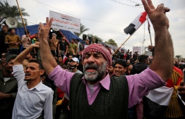 Iraqi demonstrators shout slogans as thee take part in an anti-government demonstration in the capital Baghdad's Tahrir Square, on December 6, 2019. - Tahrir has become a melting pot of Iraqi society, occupied day and night by thousands of demonstrators angry with the political system in place since the aftermath of the US-led invasion of 2003 and Iran's role in propping it up. (Photo by AHMAD AL-RUBAYE / AFP)
