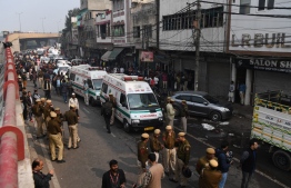 Police personnel and ambulances are seen  along a road following a factory fire in Anaj Mandi area of New Delhi on December 8, 2019. - At least 43 people have died in a factory fire in India's capital New Delhi, with the toll still expected to rise, police told AFP on December 8. The blaze broke out in the early hours in the city's old quarter, whose narrow and congested lanes are lined with many small manufacturing and storage units. (Photo by Sajjad  HUSSAIN / AFP)