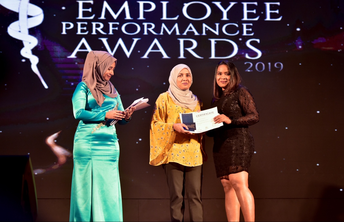 މާލެ- ޑިސެމްބަރު 8، 2019: އޭޑީކޭ ހޮސްޕިޓަލްގެ މުވައްޒަފުންގެ އަގު ވަޒަން ކުރަން ބޭއްވި ހަފްލާގައި އެހޮސްޕިޓަލްގެ މިދިޔަ އަހަރު ޕާފޯމަންސް އެވޯޑު ލިބުނު މުވައްޒަފަކާ އިނާމު ހަވާލު ކުރައްވަނީ --. ފޮޓޯ: ނިޝާން އަލީ/ މިހާރު