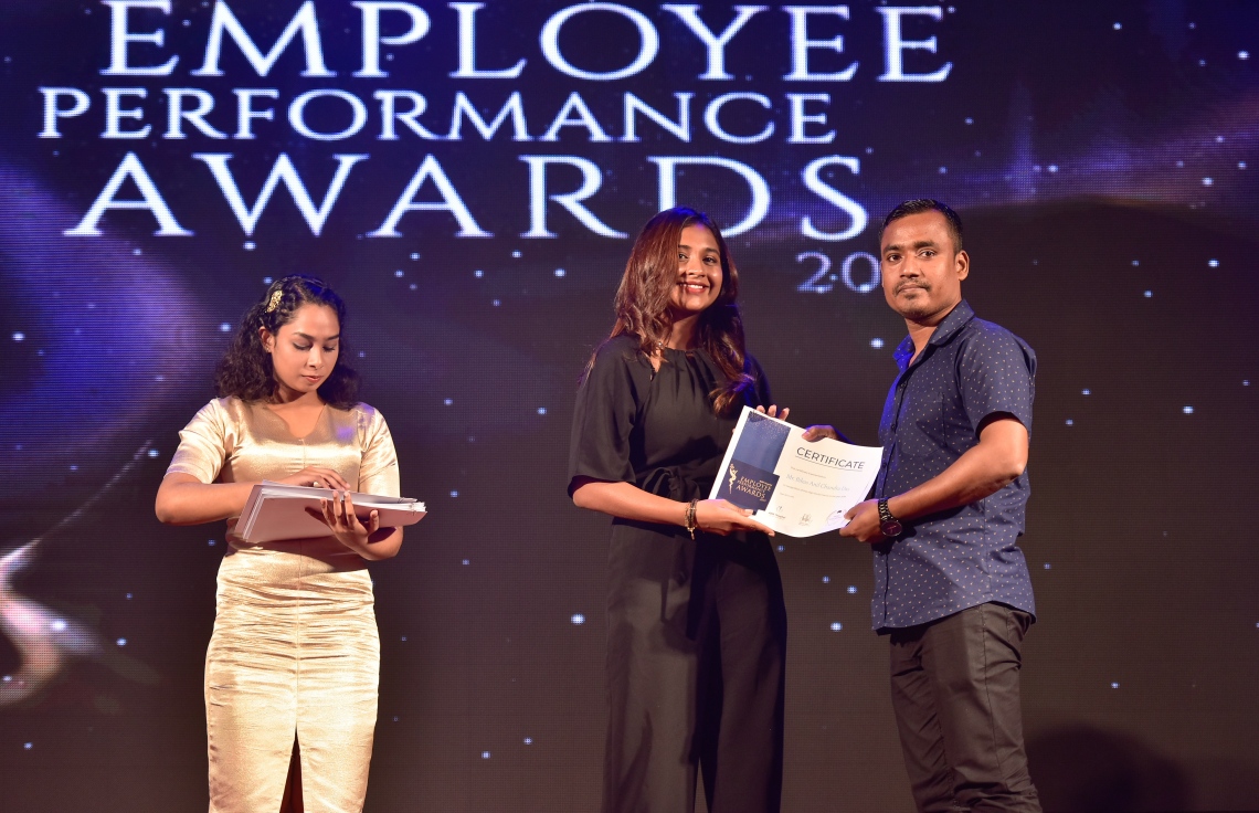 މާލެ- ޑިސެމްބަރު 8، 2019: އޭޑީކޭ ހޮސްޕިޓަލްގެ މުވައްޒަފުންގެ އަގު ވަޒަން ކުރަން ބޭއްވި ހަފްލާގައި އެހޮސްޕިޓަލްގެ މިދިޔަ އަހަރު ޕާފޯމަންސް އެވޯޑު ލިބުނު މުވައްޒަފަކާ އިނާމު ހަވާލު ކުރައްވަނީ --. ފޮޓޯ: ނިޝާން އަލީ/ މިހާރު