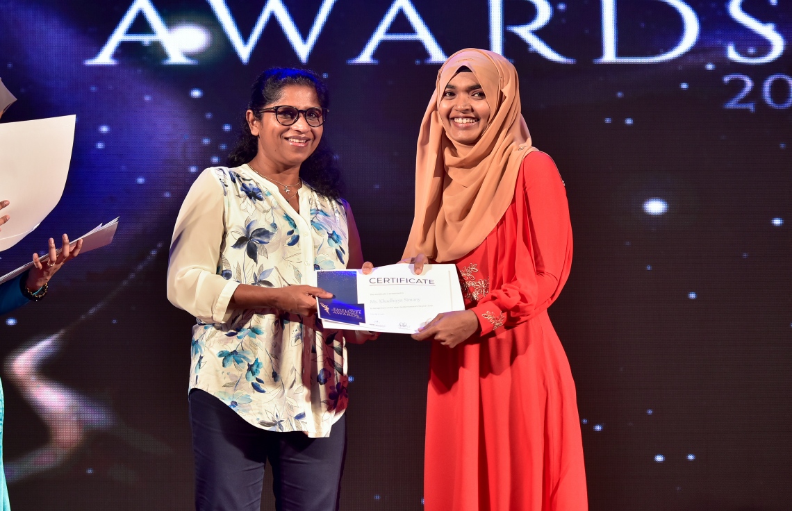 މާލެ- ޑިސެމްބަރު 8، 2019: އޭޑީކޭ ހޮސްޕިޓަލްގެ މުވައްޒަފުންގެ އަގު ވަޒަން ކުރަން ބޭއްވި ހަފްލާގައި އެހޮސްޕިޓަލްގެ މިދިޔަ އަހަރު ޕާފޯމަންސް އެވޯޑު ލިބުނު މުވައްޒަފަކާ އިނާމު ހަވާލު ކުރައްވަނީ --. ފޮޓޯ: ނިޝާން އަލީ/ މިހާރު