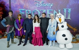 In this file photo taken on November 17, 2019 US actor Josh Gad (3rd L), US actor Idina Menzel (C) and US actor Jonathan Groff (3rd R) pose with people dressed as characters from the film on the red carpet as they arrive to attend the European premiere of the film "Frozen 2" in London. - In a rare show of box-office stasis, the top five films in North American theaters were unchanged this weekend from last, led again by Disney blockbuster "Frozen 2," industry watcher Exhibitor Relations said Sunday. (Photo by Niklas HALLE'N / AFP)