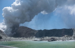 This handout photograph courtesy of Michael Schade shows the volcano on New Zealand's White Island spewing steam and ash minutes following an eruption on December 9, 2019. - New Zealand police said at least one person was killed and more fatalities were likely, after an island volcano popular with tourists erupted on December 9 leaving dozens stranded. (Photo by Handout / Michael Schade / AFP)