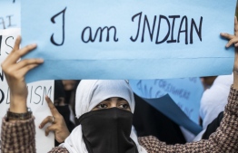 Protesters display placards during a demonstration against the Indian government's Citizenship Amendment Bill in New Delhi on December 14, 2019. - Protests against a divisive new citizenship law raged on December 14 as Washington and London issued travel warnings for northeast India following days of violent clashes that have killed two people so far. (Photo by Jewel SAMAD / AFP)