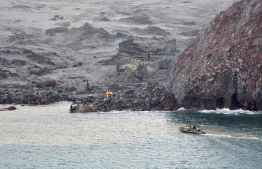This handout photo taken and released on December 13, 2019 by the New Zealand Defence Force shows elite soldiers taking part in a mission to retrieve bodies from White Island after the December 9 volcanic eruption, off the coast from Whakatane on the North Island. - Elite soldiers retrieved six bodies from New Zealand's volatile White Island volcano on December 13, winning praise for their "courageous" mission carried out under the threat of another eruption. (Photo by Handout / NEW ZEALAND DEFENCE FORCE / AFP) / 