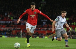 Manchester United's English striker Mason Greenwood (L) runs away from Colchester United's English midfielder Tom Lapslie (R) during the English League Cup quarter-final football match between Manchester United and Colchester United at Old Trafford in Manchester, north-west England on December 18, 2019. (Photo by Lindsey Parnaby / AFP) / RESTRICTED TO EDITORIAL USE. No use with unauthorized audio, video, data, fixture lists, club/league logos or 'live' services. Online in-match use limited to 120 images. An additional 40 images may be used in extra time. No video emulation. Social media in-match use limited to 120 images. An additional 40 images may be used in extra time. No use in betting publications, games or single club/league/player publications. / 