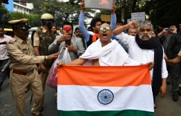 A protester dressed as Indian independence icon Mahatma Gandhi shouts slogans during a demonstration held against India's new citizenship law in spite of a curfew in Bangalore on December 19, 2019. - Indians defied bans on assembly on December 19 in cities nationwide as anger swells against a citizenship law seen as discriminatory against Muslims, following days of protests, clashes and riots that have left six dead. (Photo by Manjunath Kiran / AFP)
