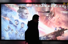 (FILES) This file photo taken on December 19, 2019 shows a man walking past a poster for the latest Star Wars movie, "The Rise of Skywalker", in Beijing. - Jedi mind tricks don't work on China. While "Star Wars" fans from around the world waited in line for days to catch "The Rise of Skywalker," the sci-fi series has struggled to woo film-goers in the increasingly important Chinese market. (Photo by GREG BAKER / AFP) / 