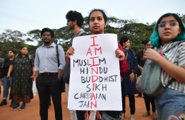Protesters hold placards during a demonstration held against India's new citizenship law in spite of a curfew in Bangalore on December 20, 2019. - Five more protesters died in fresh clashes on December 20 between Indian police and demonstrators, taking the death toll to 14 from more than a week of unrest triggered by a citizenship law seen as anti-Muslim, as thousands rallied at the nation's biggest mosque. (Photo by Manjunath Kiran / AFP)