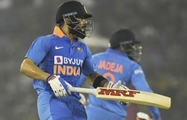 India's captain Virat Kohli (L) runs to complete a run during the third one day international cricket match of a three-match series between India and West Indies at the Barabati Stadium in Cuttack on December 22, 2019. (Photo by Dibyangshu SARKAR / AFP) / 