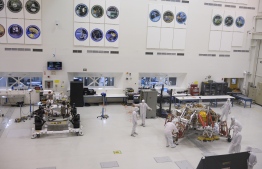 NASA engineers and technicians move the Mars 2020 spacecraft descent stage (R) closer to the Mars 2020 Rover (L), December 27, 2019 during a media tour of the spacecraft assembly area clean room at NASA's Jet Propulsion Laboratory in Pasadena, California. - The Mars 2020 rover, which will take off in a few months to the Red Planet, will not only search for possible traces of past life, it will also serve as a "precursor to a human mission to Mars," NASA scientists said December 27, 2019, when presenting the spacecraft to the press.
The Martian robot made its first turns of wheel last week in the large sterile room of the Jet Propulsion Laboratory (JPL) in Pasadena, near Los Angeles, where it was born. It is scheduled to leave Earth in July 2020 from Cape Canaveral (Florida) and land on Mars in February 2021. (Photo by Robyn Beck / AFP)