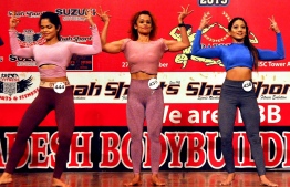 In this picture taken on December 29, 2019, competitors perform on stage during Bangladesh's first bodybuilding competition for women, in Dhaka. - A 19-year-old student has become Bangladesh's first women's bodybuilding champion after a contest in which most of her muscle was covered up to prevent controversy in the Muslim-majority nation. While skimpy bikinis are the norm at many international body-building contests, Awhona Rahman and her 29 rivals kept their brawn under wraps in front of the crowd of hundreds. (Photo by STR / AFP)