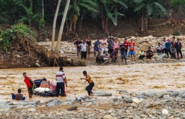 Villagers use inflated inner tire tubes to deliver supplies across a river at the Banjar Irigasi village in Lebak, Banten province on January 2, 2020, after flooding triggered by heavy rain hit the area. - Indonesia's disaster agency warned on January 2 of more deaths after torrential rains pounded the Jakarta region, triggering floods and landslides that killed at least 23 and left vast swaths of the megalopolis underwater. (Photo by SAMMY / AFP)