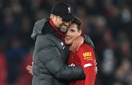 Liverpool's German manager Jurgen Klopp (L) embraces Liverpool's Scottish defender Andrew Robertson (R) at the end of the English Premier League football match between Liverpool and Wolverhampton Wanderers at Anfield in Liverpool, north west England, on December 29, 2019. PHOTO: PAUL ELLIS / AFP
