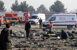 Rescue teams work amidst debris after a Ukrainian plane carrying 176 passengers crashed near Imam Khomeini airport in the Iranian capital Tehran early in the morning on January 8, 2020, killing everyone on board. - The Boeing 737 had left Tehran's international airport bound for Kiev, semi-official news agency ISNA said, adding that 10 ambulances were sent to the crash site. (Photo by - / AFP)