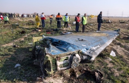 Rescue teams are seen on January 8, 2020 at the scene of a Ukrainian airliner that crashed shortly after take-off near Imam Khomeini airport in the Iranian capital Tehran. - Search-and-rescue teams were combing through the smoking wreckage of the Boeing 737 flight from Tehran to Kiev but officials said there was no hope of finding anyone alive. The vast majority of the passengers on the Ukraine International Airlines flight were non-Ukrainians, including 82 Iranians and 63 Canadians, officials said. (Photo by Akbar TAVAKOLI / IRNA / AFP)