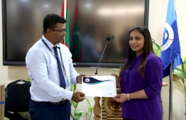 MPL's Chief Executive Officer Shahid Ali (L) presents 10 computer systems,gifted by MPL to the education ministry, to Minister Dr Aishath Ali. PHOTO/MPL