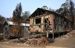 This photo taken on January 11, 2020 shows accommodation blocks at the Gold Rush Colony in Mogo, a tourist attraction dedicated to Mogo's 1850s gold rush -- where a recent bushfire reduced it to twisted metal and ash. - The unprecedented scale Australia's summer's bushfires have tainted the country's reputation as a safe and alluring holiday destination. Thousands of tourists were evacuated from coastal towns, international visitors have cancelled flights, and the US State Department even upgraded its security advice for Australia -- warning travellers to "exercise increased caution" due to the bushfire risk. (Photo by PETER PARKS / AFP) / 