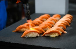 A chef prepares scorched salmon nigiri sushi at Nihonbashi Blue. PHOTO/NIHONBASHI BLUE