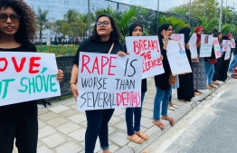 Young women holding signboards amidst a protest sparked by the sexual abuse of a 21-month old in Kanduhulhudhoo, Gaafu Alif Atoll. PHOTO: MV CRISIS