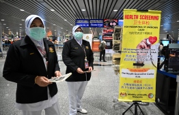 Malaysian health officers are deployed at Kuala Lumpur International Airport in Sepang on January 21, 2020 as authorities increased measure against coronavirus. (Photo by MOHD RASFAN / AFP)