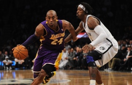 (FILES) In this file photo taken on February 05, 2013 Los Angeles Lakers' Kobe Bryant drives the ball past Brooklyn Nets Gerald Wallace during their NBA game at the Barclays Center in the Brooklyn borough of New York City. - NBA legend Kobe Bryant died Sunday when a helicopter crashed and burst into flames in foggy conditions in suburban Los Angeles, killing all nine people on board and plunging the sports world into mourning. (Photo by Emmanuel DUNAND / AFP)