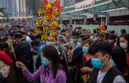 People wear masks as they visit Wong Tai Sin temple on the first day of the Lunar New Year of the Rat in Hong Kong on January 25, 2020, as a preventative measure following a coronavirus outbreak which began in the Chinese city of Wuhan. - Hong Kong on January 25 declared a mystery virus outbreak as an "emergency" -- the city's highest warning tier -- as authorities ramped up measures aimed at reducing the risk of further infections spreading. PHOTO: DALE DE LA REY / AFP