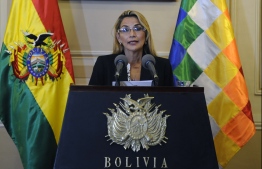 (FILES) In this file picture taken on November 13, 2019 Bolivia's interim president Jeanine Anez speaks during a press conference on her first day in power, at Quemado Presidential Palace in La Paz. - Anez asked for the resignation of all her ministers on January 26, 2020, two days after announcing she would stand in the May 3 presidential election and just hours after her Communications minister presented her resignation over such decision. A little-known senator, Anez assumed the presidency on November 12, two days aftern ow ex-president Evo Morales resigned following three weeks of sometimes violent protests against his controversial re-election in a poll the Organization of American States said was rigged. (Photo by JORGE BERNAL / AFP)