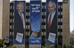 (FILES) In this file photo taken on September 4, 2019, Israeli election banner for the Likud party showing US President Donald Trump shaking hands with Likud chairman and Prime Minister Benjamin Netanyahu hangs on the facade of a building in Jerusalem. - A peace plan with no chance of achieving peace: that's the paradox of Washington's proposal for an Israeli-Palestinian accord expected by January 28, 2020. A major obstacle to any such plan is that President Donald Trump has aligned himself so strongly with Israel, while repeatedly undercutting the Palestinian side, that in the eyes of the latter the US has lost its status as an "honest broker." The plan, described by the American president as "the ultimate deal," seeks to bridge major gaps between the Israeli and Palestinian sides, a goal that has eluded previous administrations reaching back for decades. Trump's son-in-law and adviser Jared Kushner began working on the proposal in 2017 in a largely secretive process. (Photo by AHMAD GHARABLI / AFP)