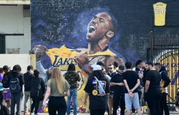 Fans gather to mourn the death of NBA legend Kobe Bryant at a mural near Staples Center in Los Angeles, California on January 27, 2020, a day after nine people were killed in the helicopter crash which claimed the life of the former Los Angeles Lakers star and his 13 year old daughter. - Nine people were killed in the helicopter crash which claimed the life of NBA star Kobe Bryant and his 13 year old daughter, Los Angeles officials confirmed on Sunday. Los Angeles County Sheriff Alex Villanueva said eight passengers and the pilot of the aircraft died in the accident. The helicopter crashed in foggy weather in the Los Angeles suburb of Calabasas. Authorities said firefighters received a call shortly at 9:47 am about the crash, which caused a brush fire on a hillside. (Photo by Frederic J. BROWN / AFP)
