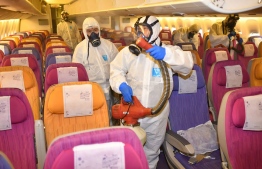 This handout from Thai Airways taken on January 28, 2020 and received on January 29, 2020 shows staff disinfecting an aircraft at the airline's hangar in Bangkok, as a measure aimed at preventing the spread of novel coronavirus. (Photo by Handout / THAI AIRWAYS / AFP)