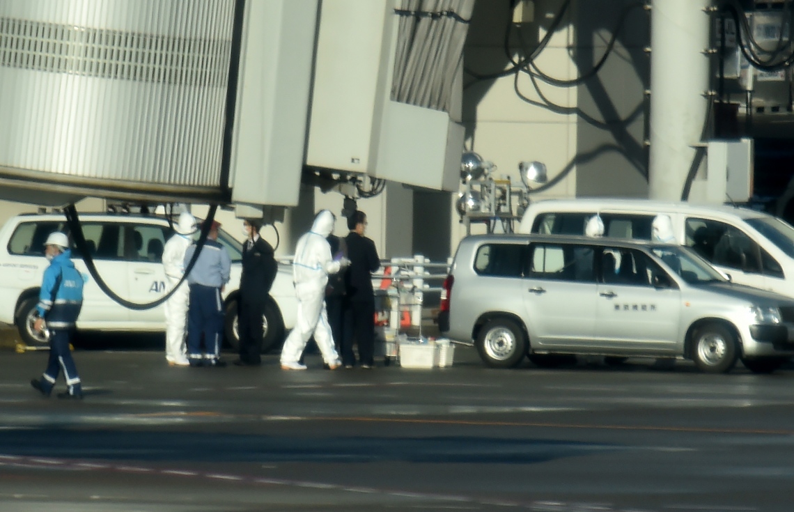 ވޫހާން ސިޓީގެ އެއާޕޯޓް އޭޕްރޮންގައި ރައްކާތެރިވުމުގެ ގޮތުން ހެދުން އަޅައިގެން ތިބި ބަޔަކު ހަރަކާތްތެރި ވަނީ. --ފޮޓޯ:އޭއެފްޕީ