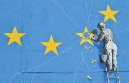 (FILES) This file photo taken on January 7, 2019 shows a mural by British artist Banksy, depicting a workman chipping away at one of the stars on a European Union (EU) themed flag,in Dover, south east England. - Britain leaves the European Union on January 31, ending more than four decades of economic, political and legal integration with its closest neighbours. (Photo by Glyn KIRK / AFP) / 