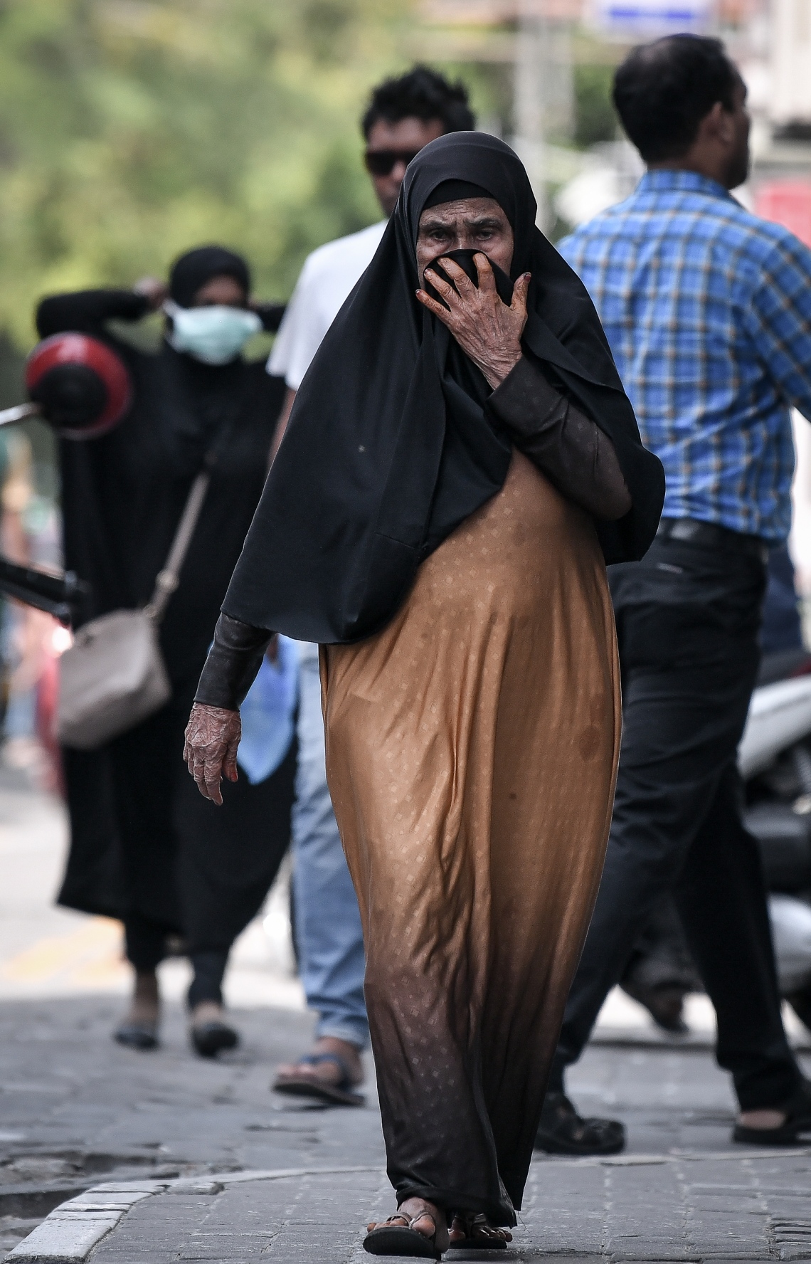 މާލެ: ޖެނުއަރީ 31، 2020: ނުރައްކާތެރި ކޮރޯނާ ވައިރަހަށް ޝައްކުކުރެވޭ މީހަކު ރާއްޖެއިން ފެނުމާ ގުޅިގެން، ރައްކާތެރިވުމުގެ ގޮތުން ހޮސްޕިޓަލެއް ކައިރިން ދާ މީހަކު މޫނުމަތީ ބުރުގާ އަޅައި ނިވާކުރަނީ--- ފޮޓޯ: ނިޝާން އަލީ/މިހާރު