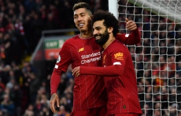 Liverpool's Egyptian midfielder Mohamed Salah (R) celebrates with Liverpool's Brazilian midfielder Roberto Firmino after scoring his team's third goal during the English Premier League football match between Liverpool and Southampton at Anfield in Liverpool, north west England on February 1, 2020. (Photo by Paul ELLIS / AFP) / RESTRICTED TO EDITORIAL USE. No use with unauthorized audio, video, data, fixture lists, club/league logos or 'live' services. Online in-match use limited to 120 images. An additional 40 images may be used in extra time. No video emulation. Social media in-match use limited to 120 images. An additional 40 images may be used in extra time. No use in betting publications, games or single club/league/player publications. / 