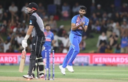 India’s Jasprit Bumrah (R) celebrates after taking the wicket of New Zealand’s Daryl Mitchell (L) during the fifth Twenty20 cricket match between New Zealand and India at the Bay Oval in Mount Maunganui on February 2, 2020. 
MICHAEL BRADLEY / AFP
